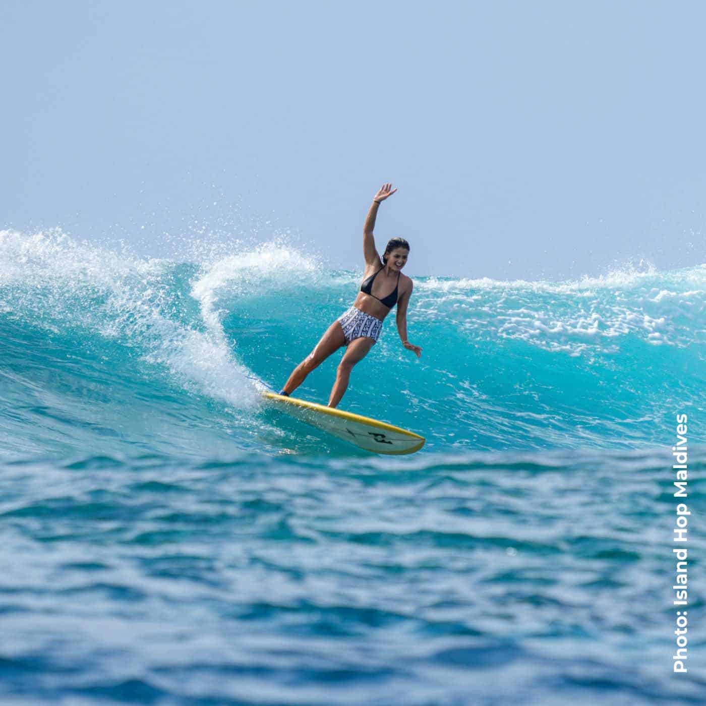 A girl surfing with Island Hop Maldives
